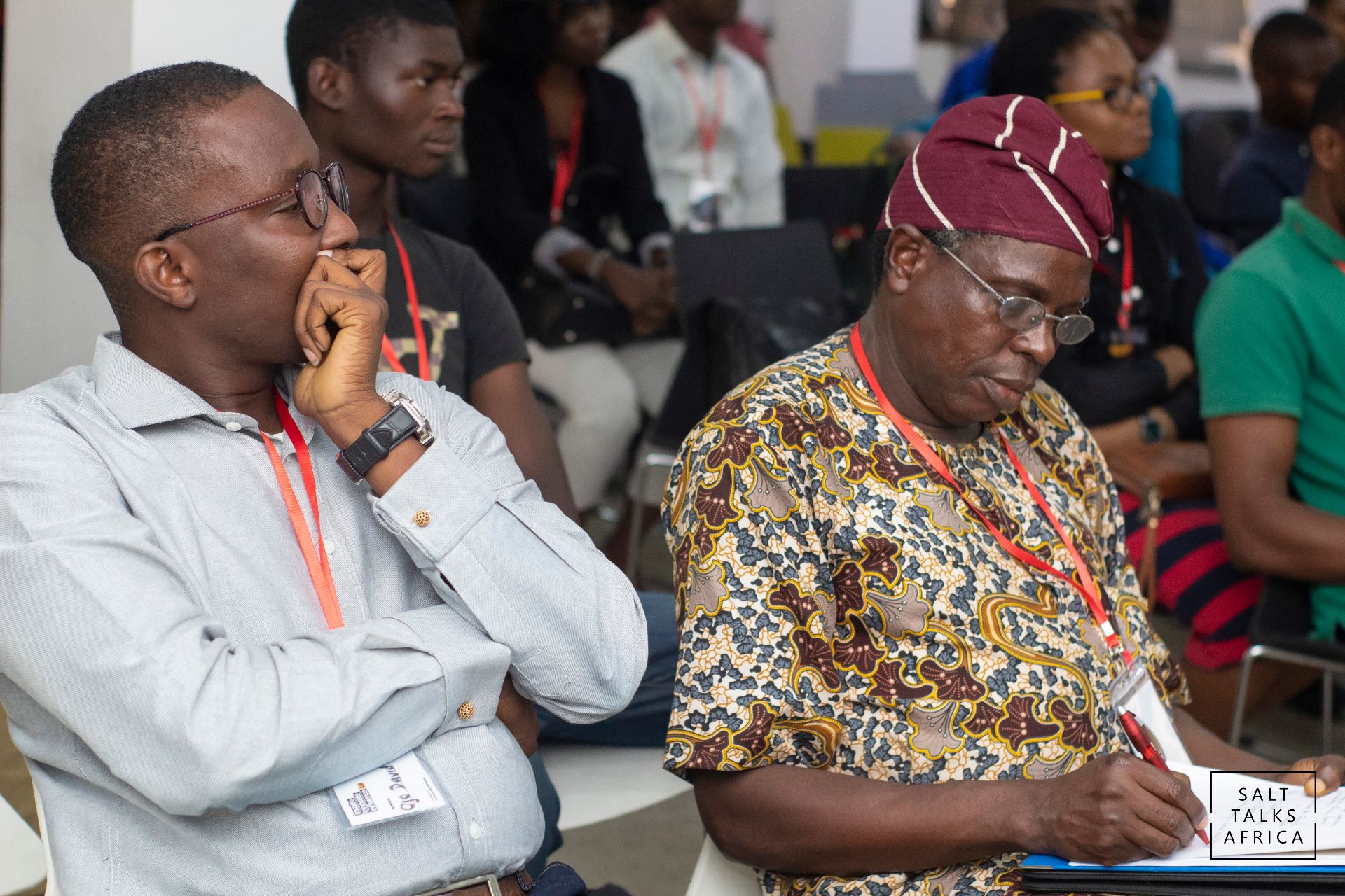 Two attendees listening and taking notes at a Salt House Africa gathering