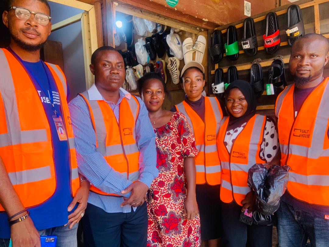 A team of six people in high-visibility vests standing together on a field assessment